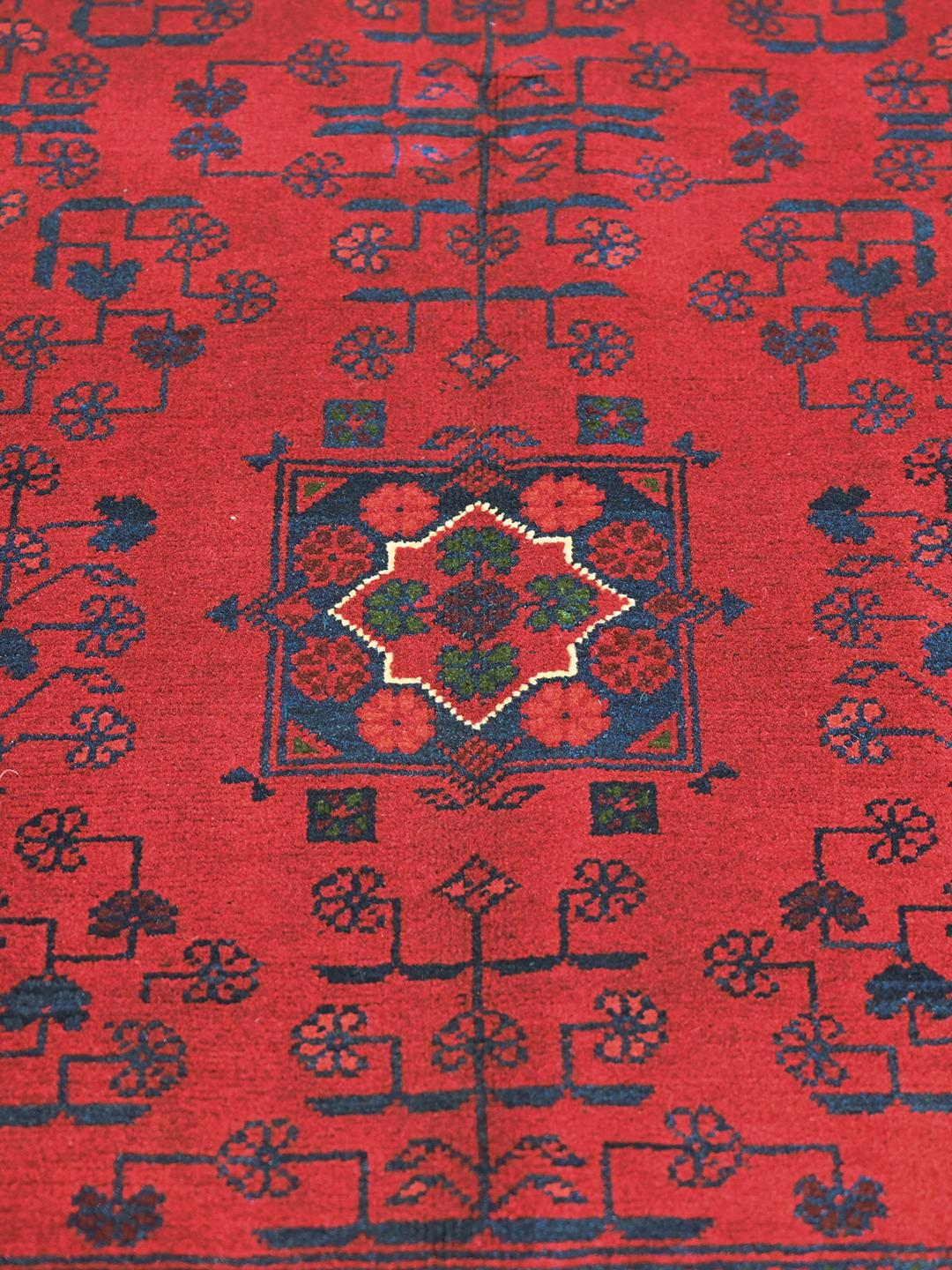 Håndlavet Kunduz-tæppe fra Afghanistan i dyb rød med traditionelle motiver.