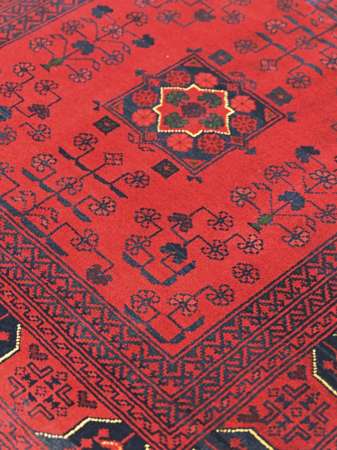 Håndlavet Kunduz-tæppe fra Afghanistan i dyb rød med traditionelle motiver.