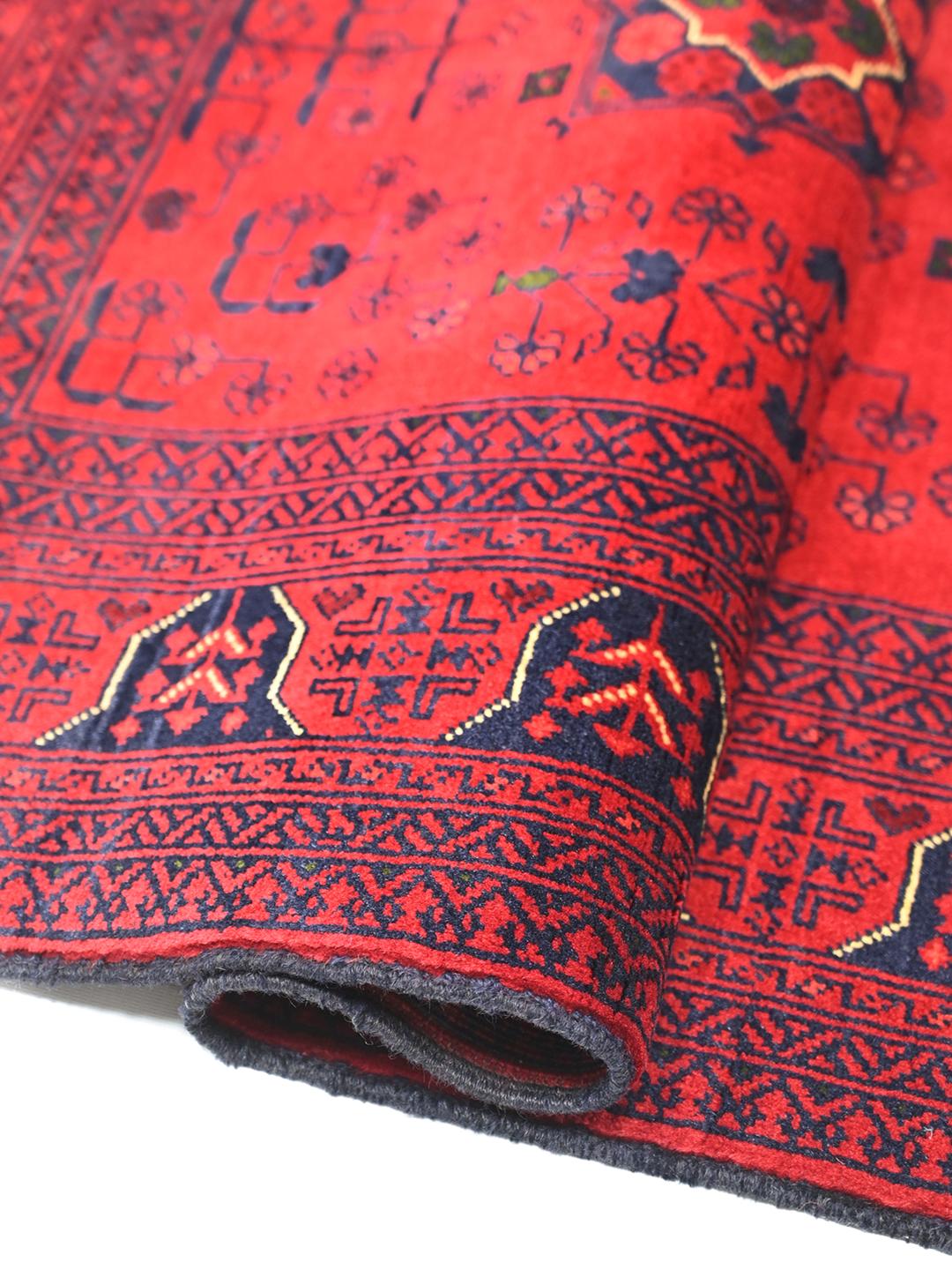 Håndlavet Kunduz-tæppe fra Afghanistan i dyb rød med traditionelle motiver.