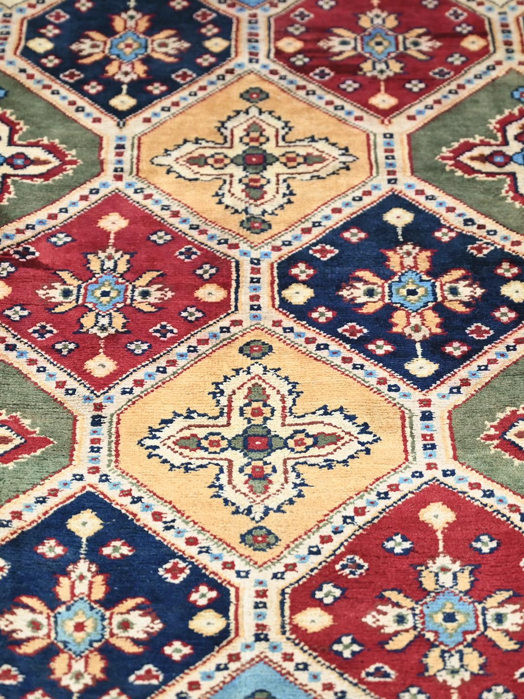 A hand-knotted Kunduz rug from the Middle East featuring a geometric diamond pattern in multicolor wool.