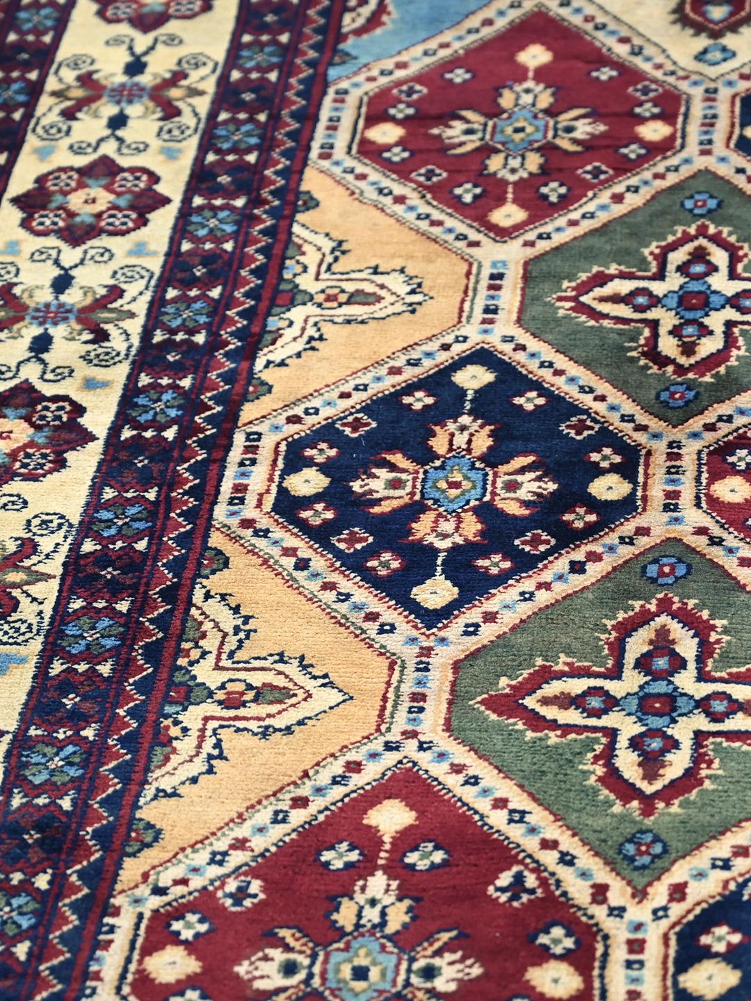 A hand-knotted Kunduz rug from the Middle East featuring a geometric diamond pattern in multicolor wool.