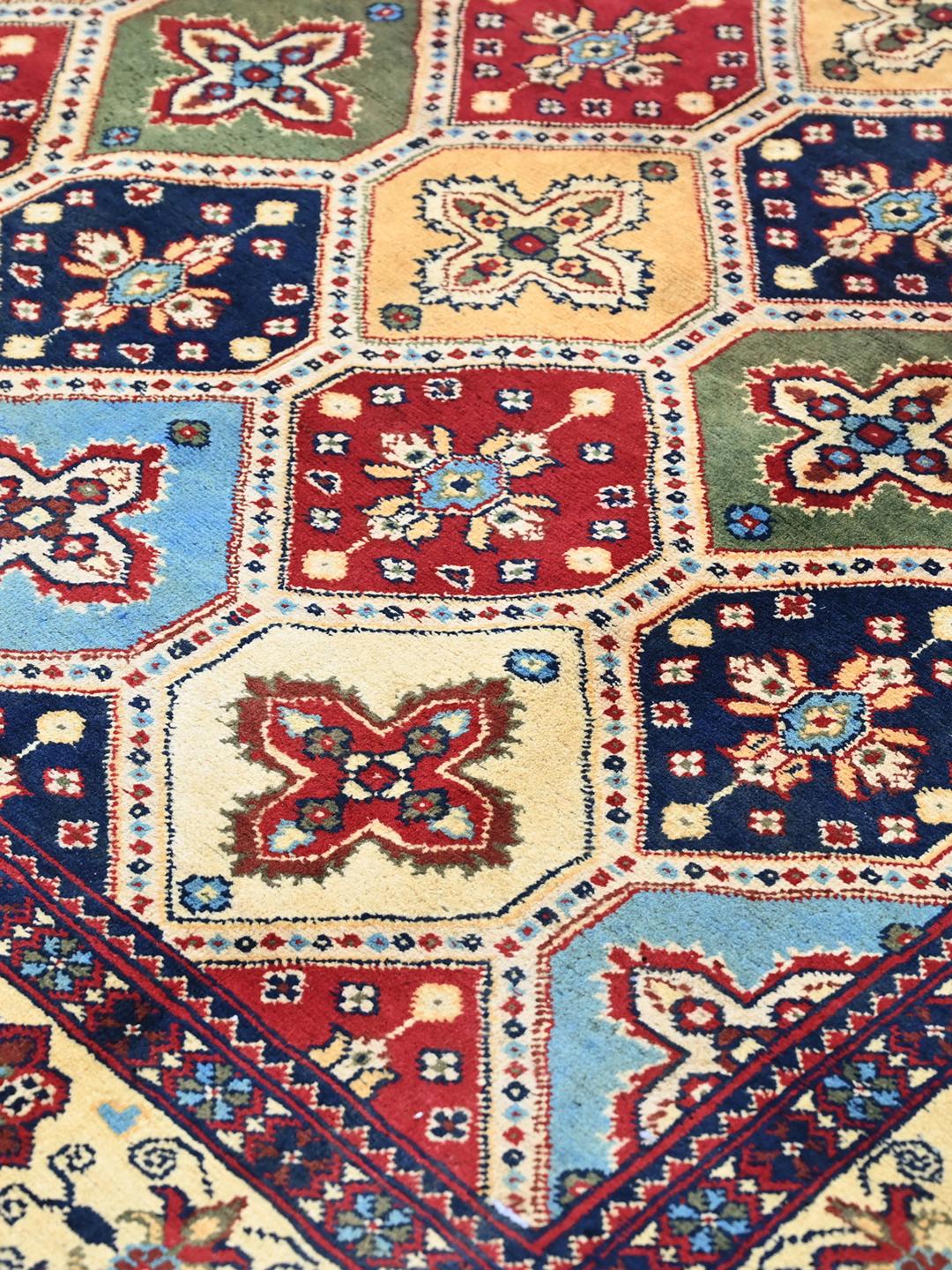A hand-knotted Kunduz rug from the Middle East featuring a geometric diamond pattern in multicolor wool.