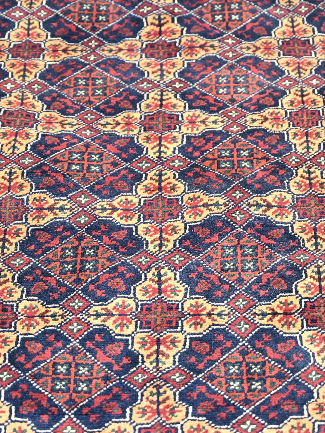 Un tapis Kunduz noué à la main originaire d'Afghanistan avec un motif géométrique rouge et bleu.