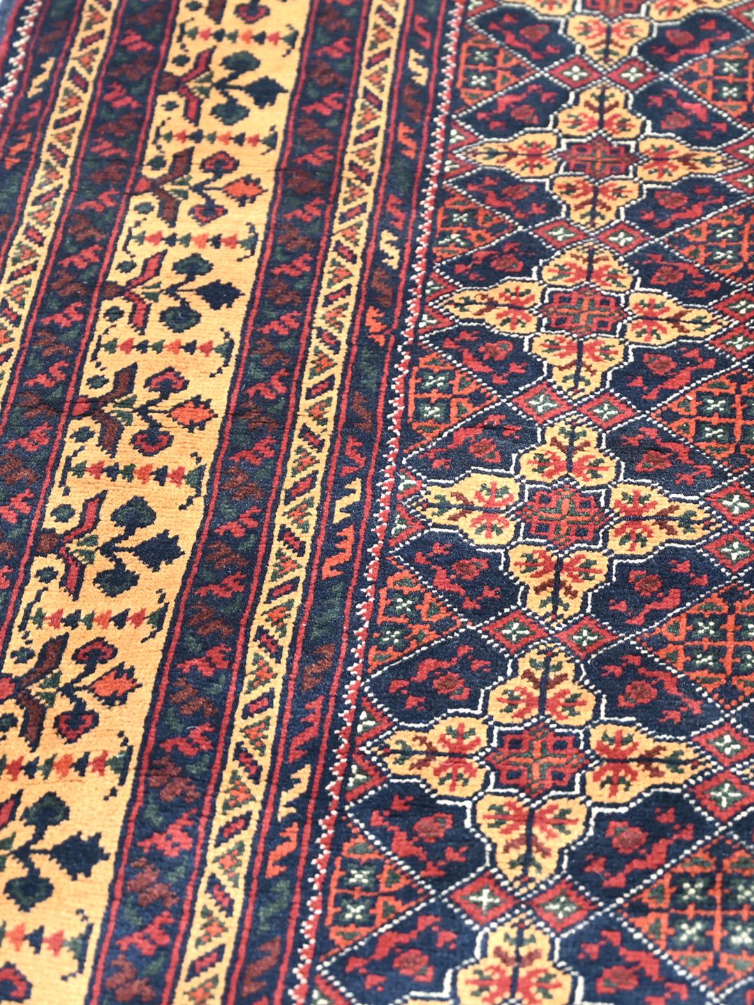 Un tapis Kunduz noué à la main originaire d'Afghanistan avec un motif géométrique rouge et bleu.