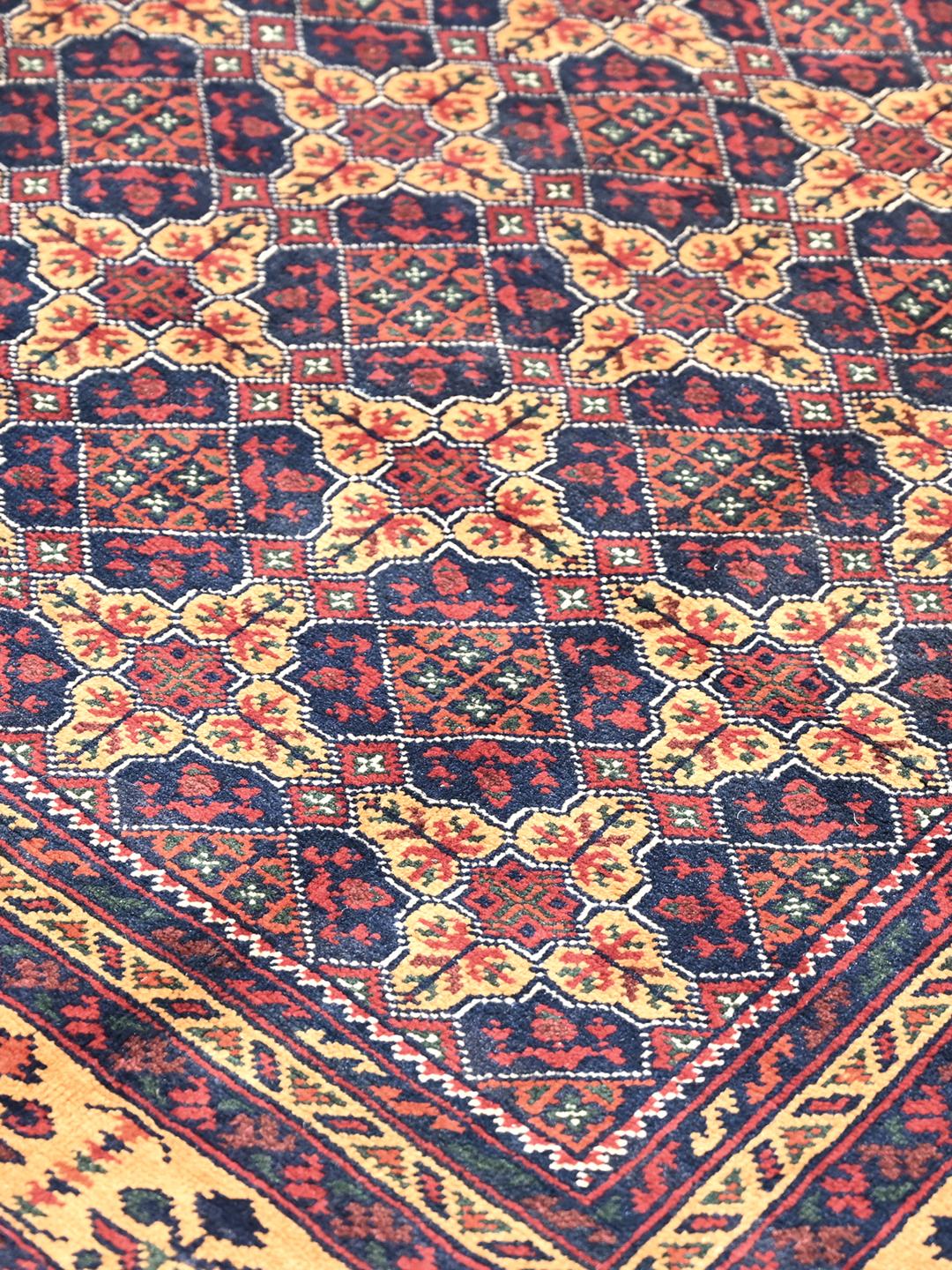 Un tapis Kunduz noué à la main originaire d'Afghanistan avec un motif géométrique rouge et bleu.