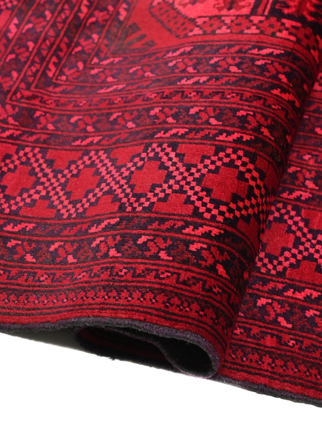 Tapis afghan Kunduz rouge noué à la main avec des motifs géométriques en médaillon.