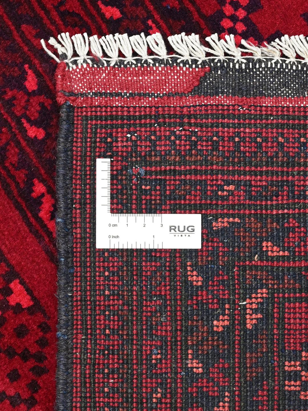 Tapis afghan Kunduz rouge noué à la main avec des motifs géométriques en médaillon.