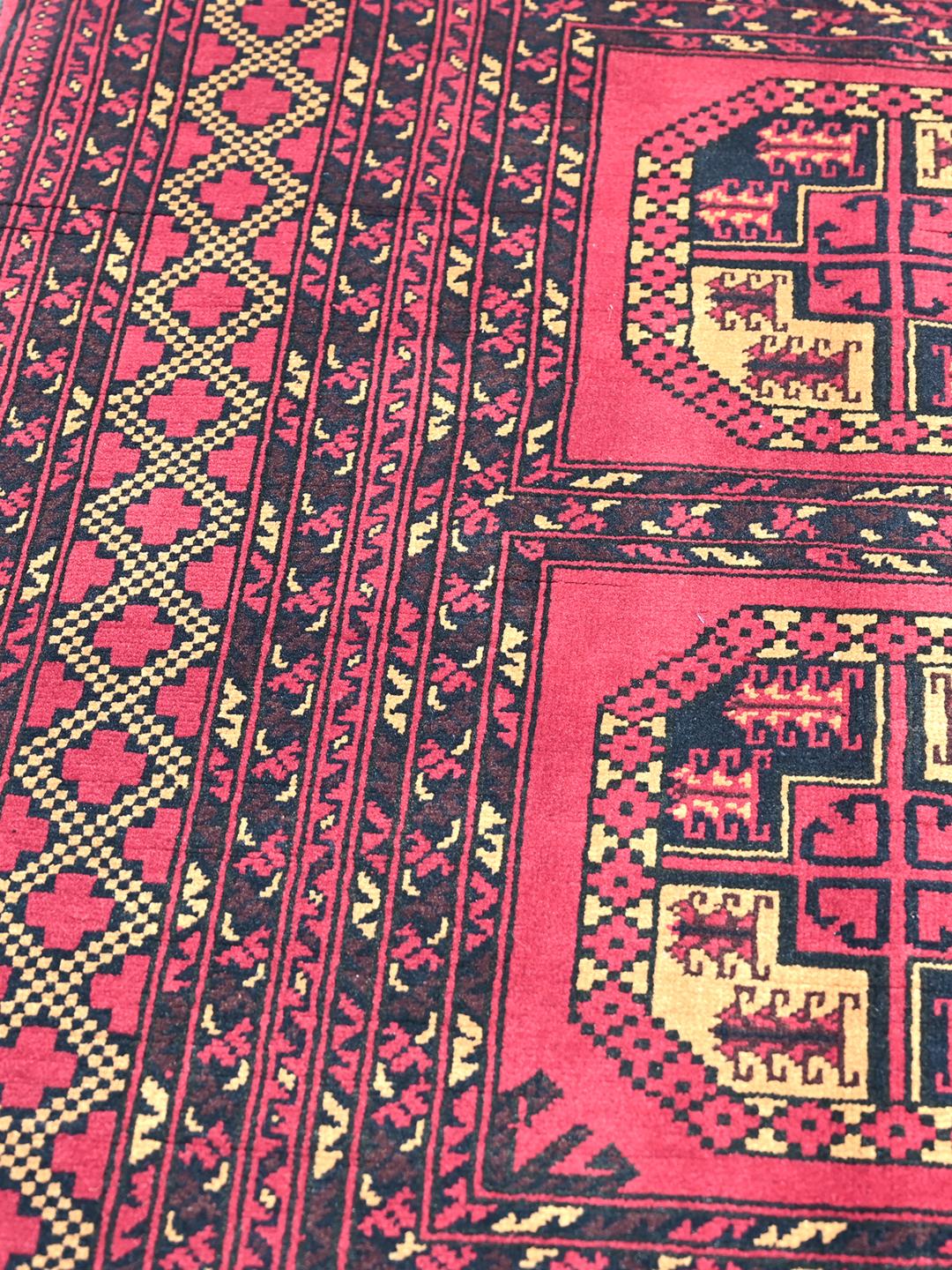 Hand-knotted Middle Eastern Kunduz rug in deep red and black tones