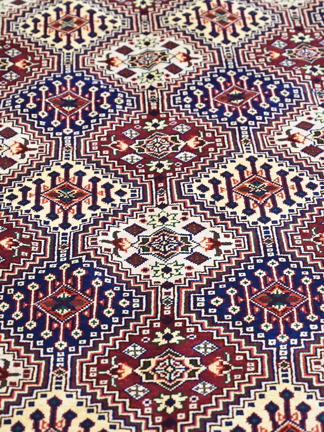 Hand-knotted red Afghan Kunduz rug with geometric patterns