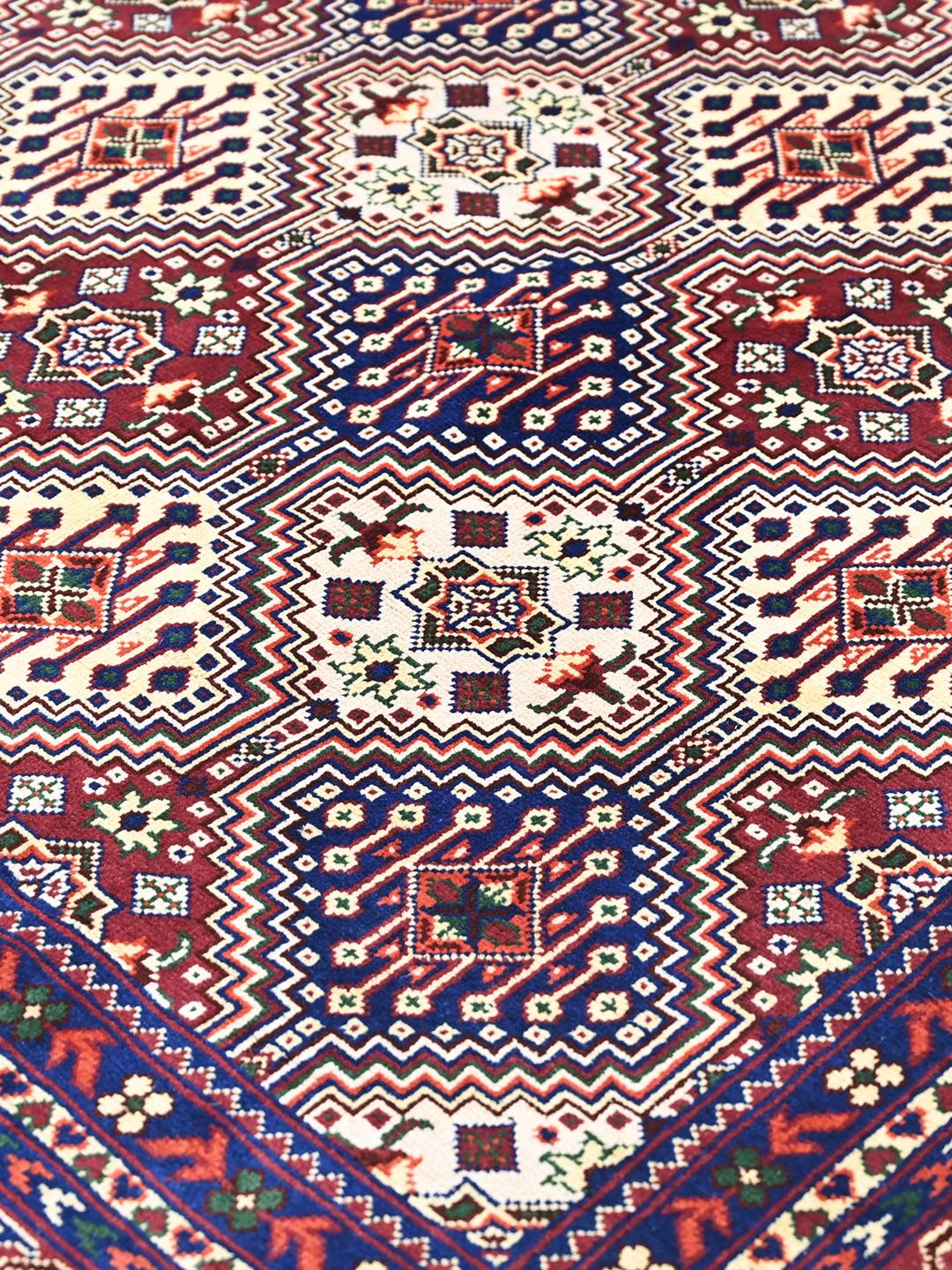 Hand-knotted red Afghan Kunduz rug with geometric patterns