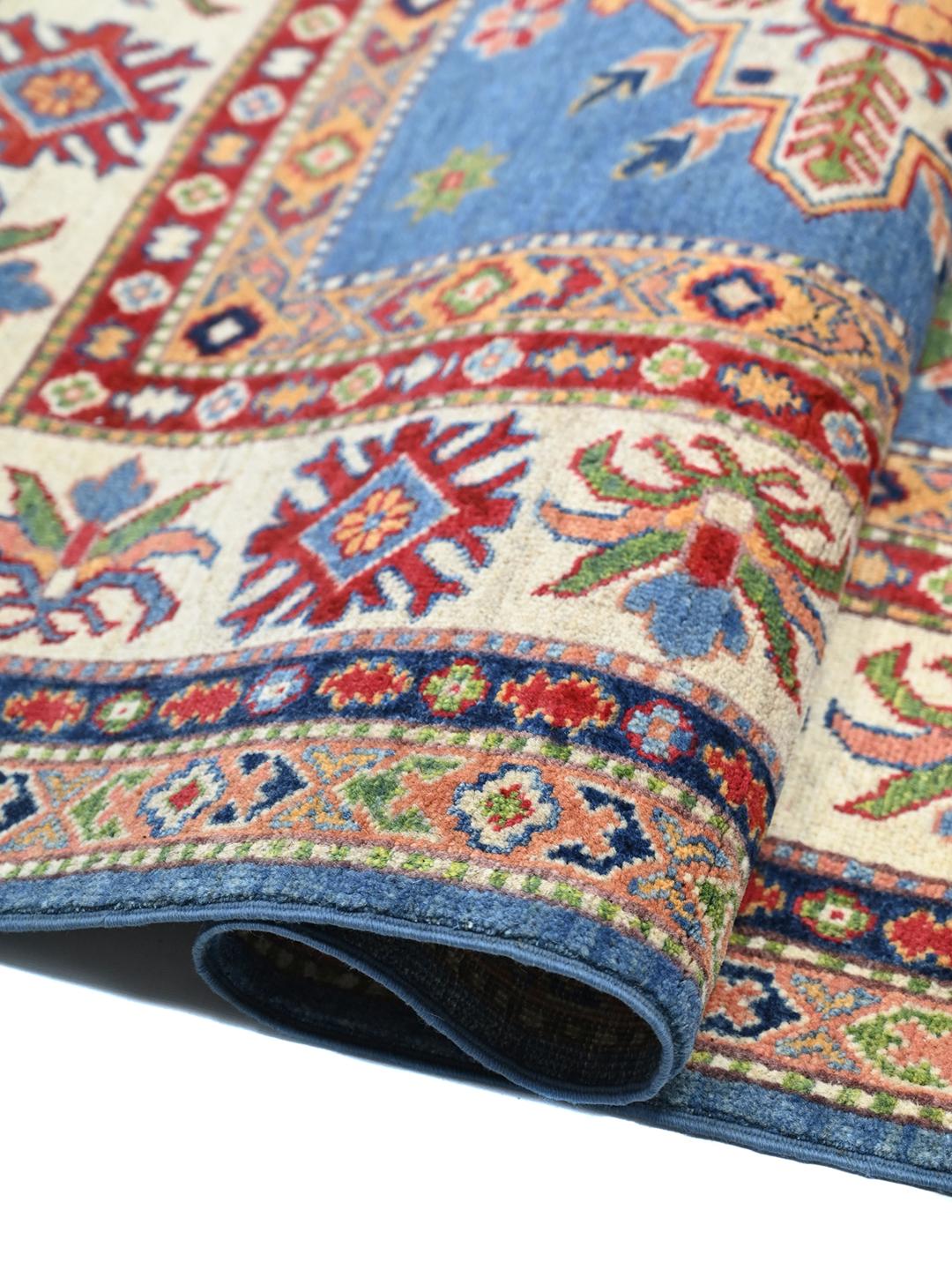Una alfombra Kazak azul anudada a mano con medallones geométricos e intrincados bordes de Afganistán.