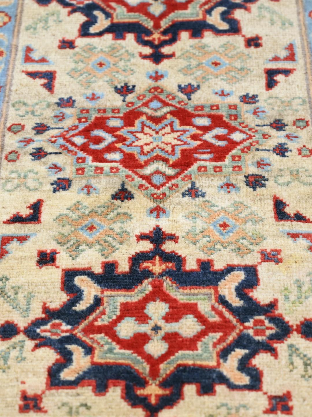 Hand-knotted Afghan Kazak Fine rug in red and blue featuring traditional tribal medallions