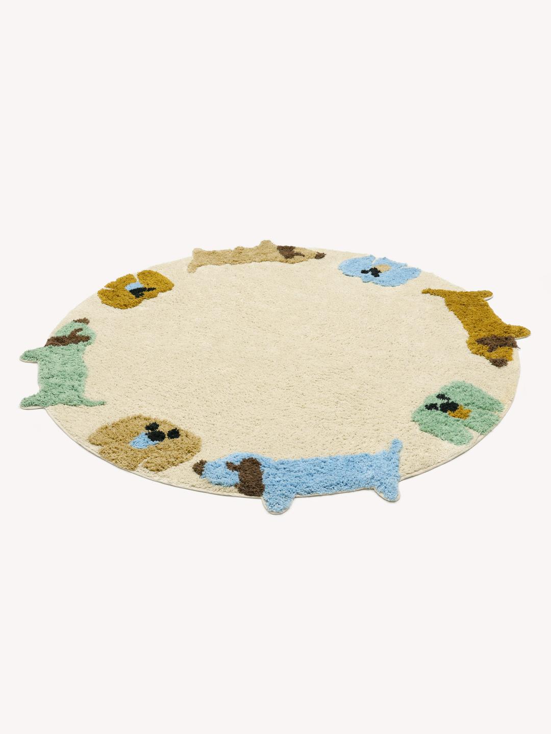 Een rond meerkleurig kinderkleed met een cirkel van pastel puppy's