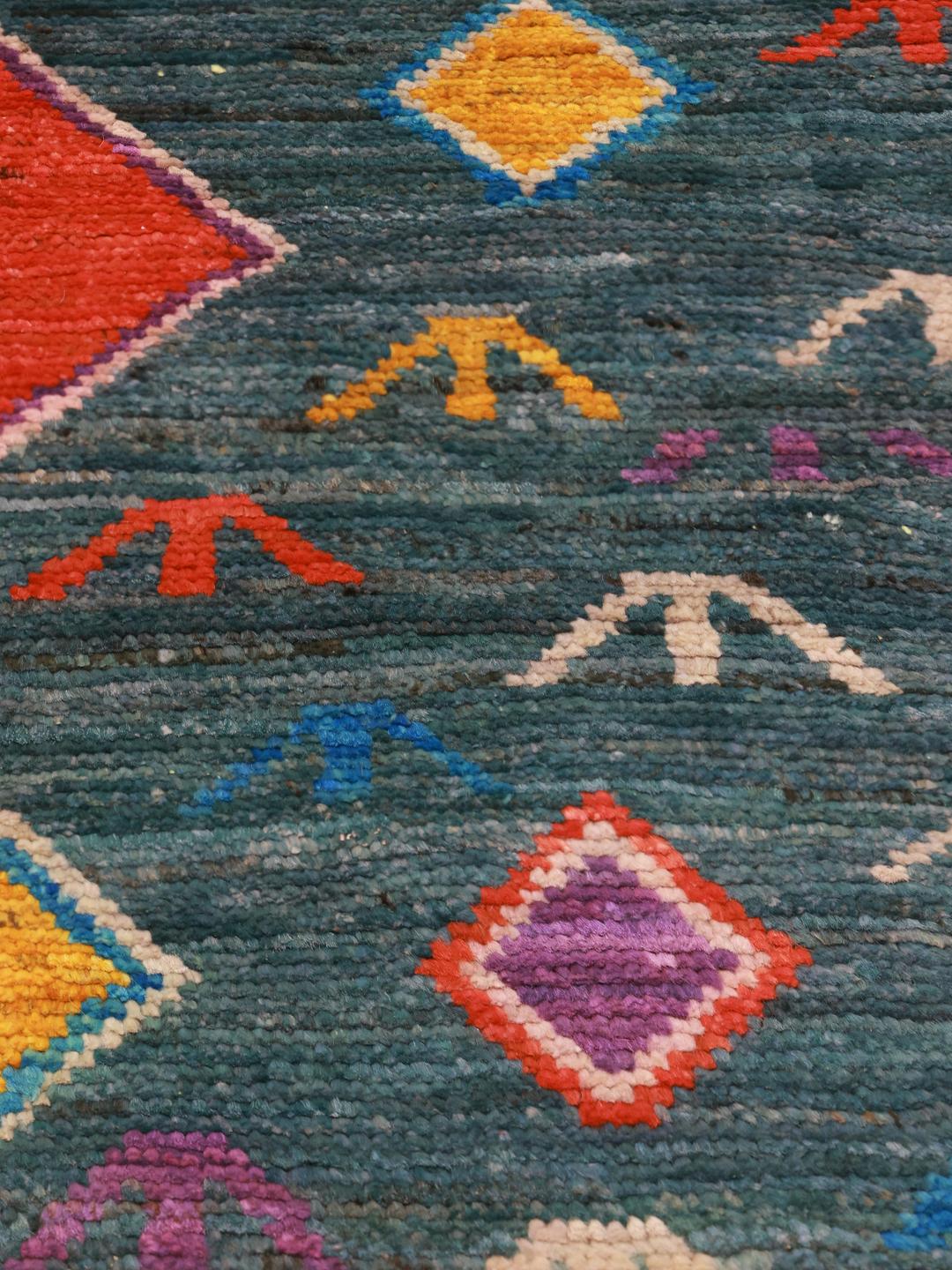 Handmade wool rug from Afghanistan in teal with colorful diamond patterns