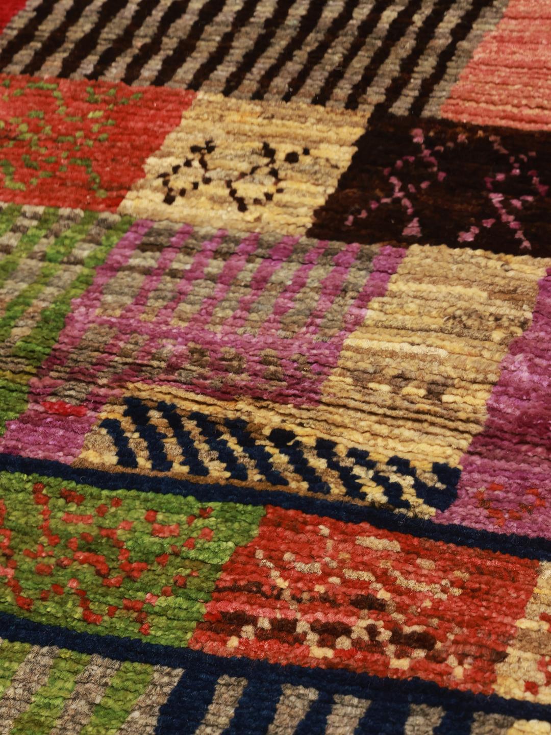 Et levende, flerfarvet håndknyttet Berber-tæppe fra Afghanistan med et patchwork-design.