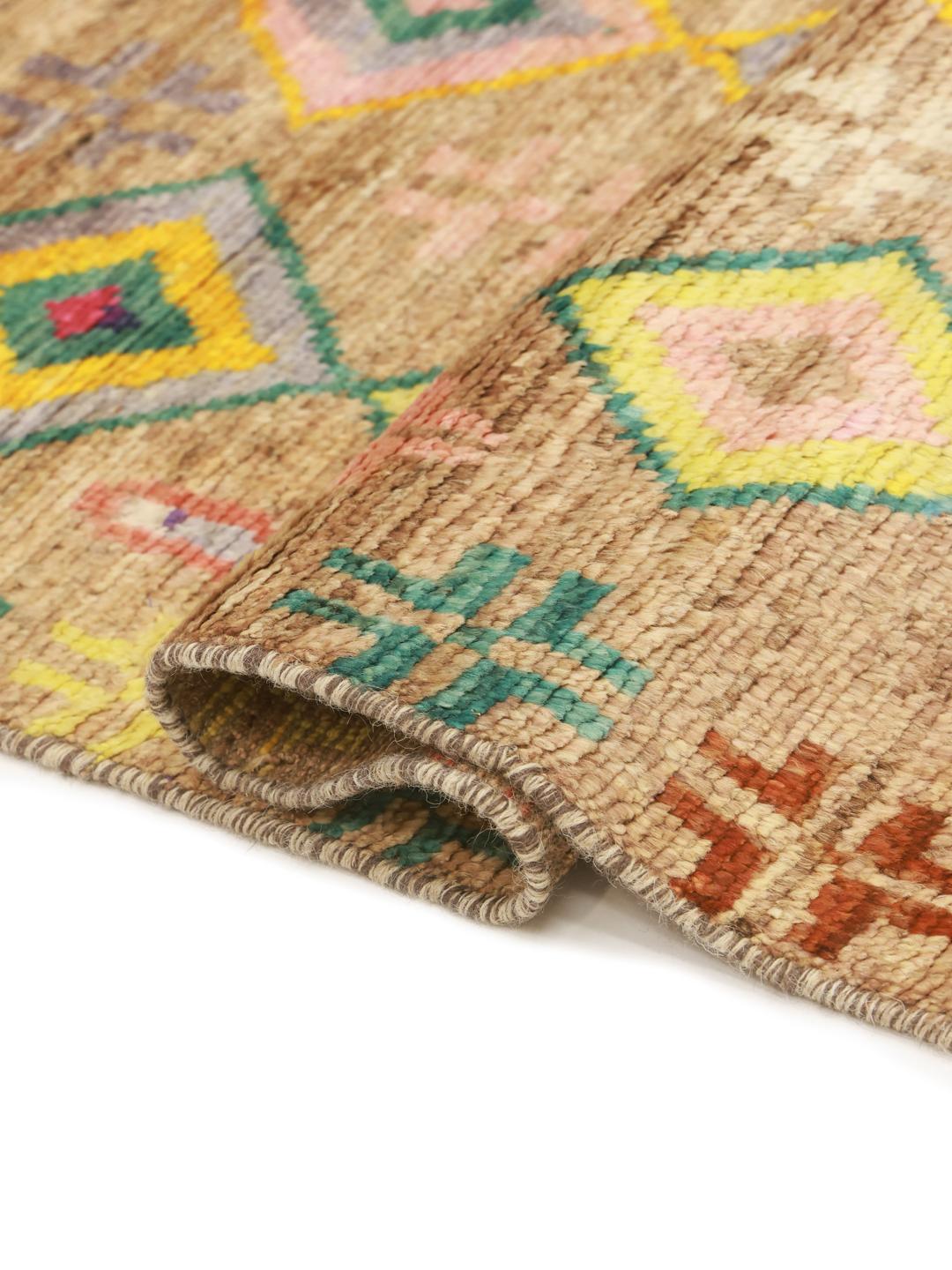 Håndknyttet afghansk tæppe med levende geometriske diamantmønstre i en beige farvepalette.