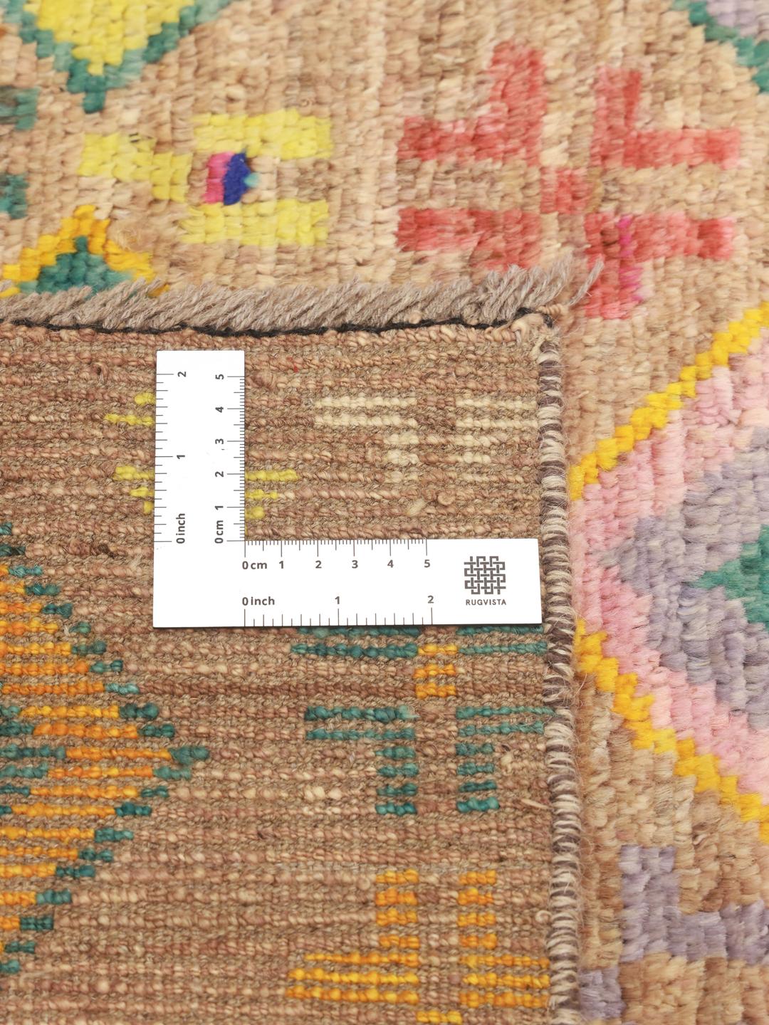 Håndknyttet afghansk tæppe med levende geometriske diamantmønstre i en beige farvepalette.