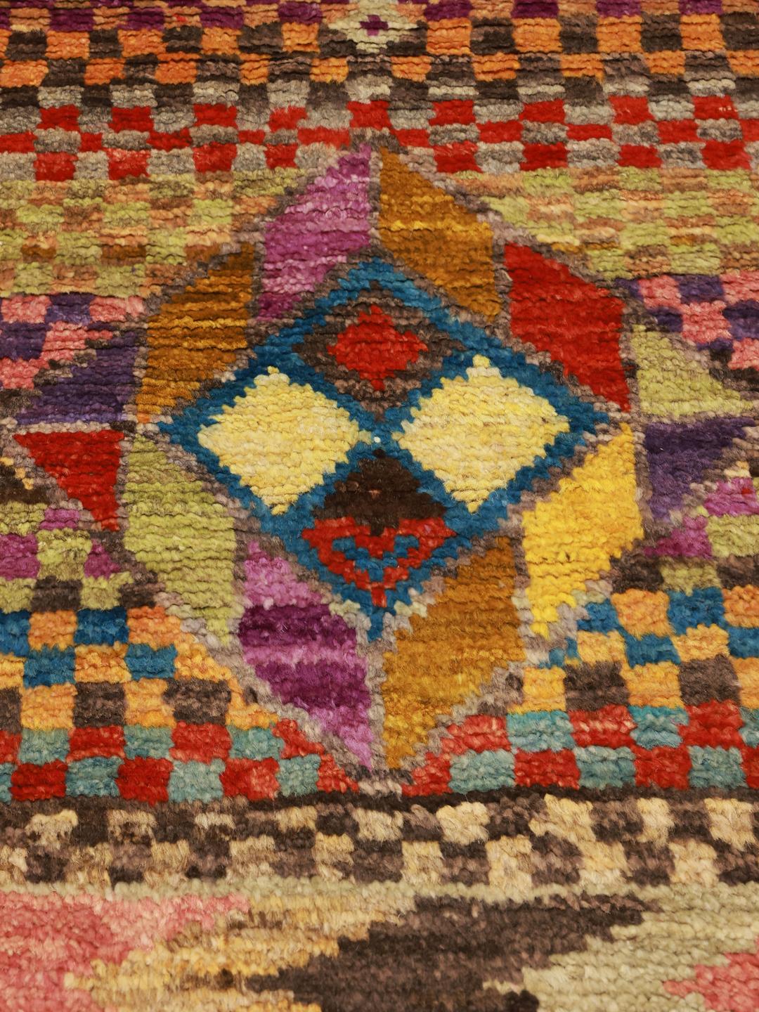 Een levendig, handgeknoopt Berber tapijt uit Afghanistan met een kleurrijk geometrisch dambordpatroon.