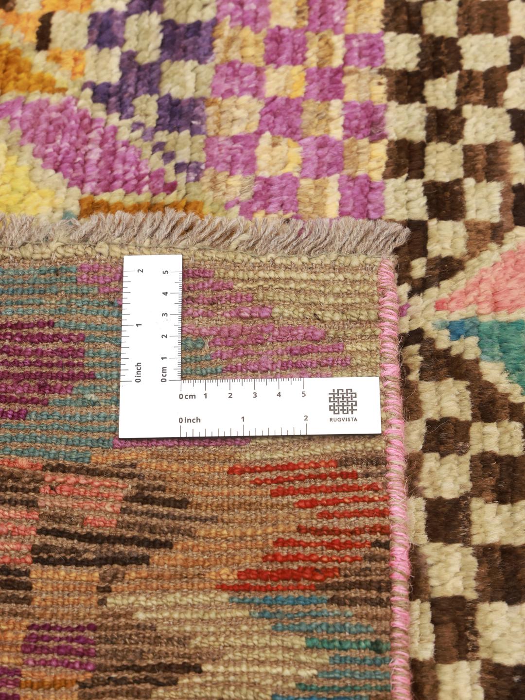 Een levendig, handgeknoopt Berber tapijt uit Afghanistan met een kleurrijk geometrisch dambordpatroon.