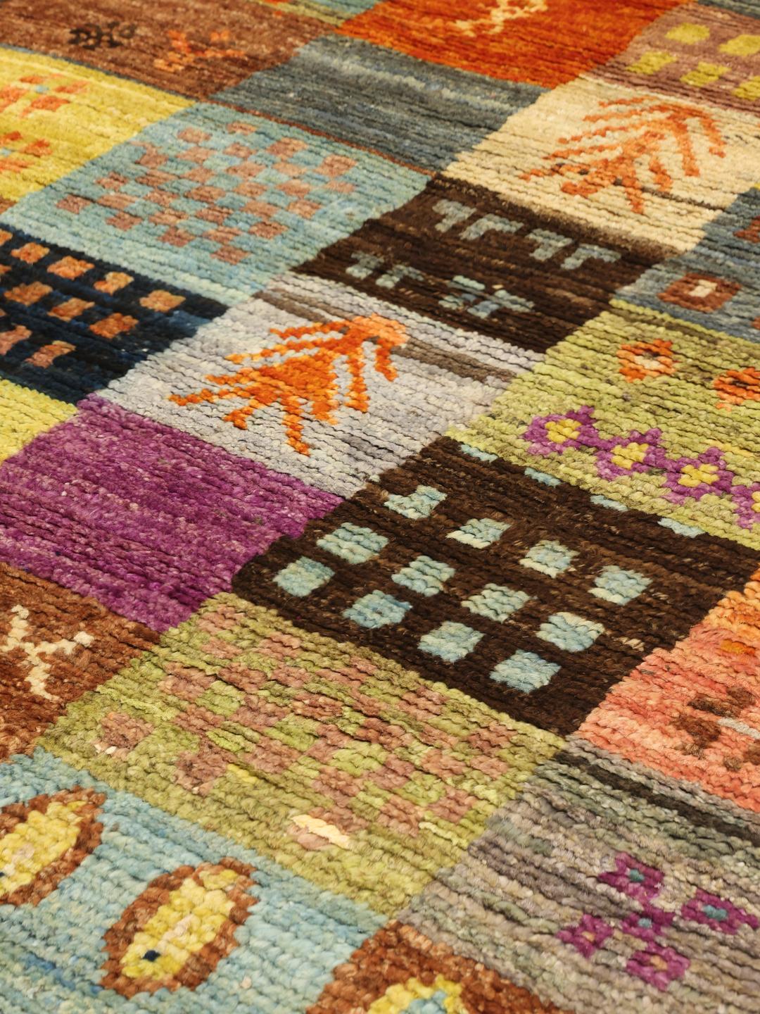 Et levende flerfarvet håndknyttet Berber-tæppe fra Afghanistan med et patchwork-mønster.