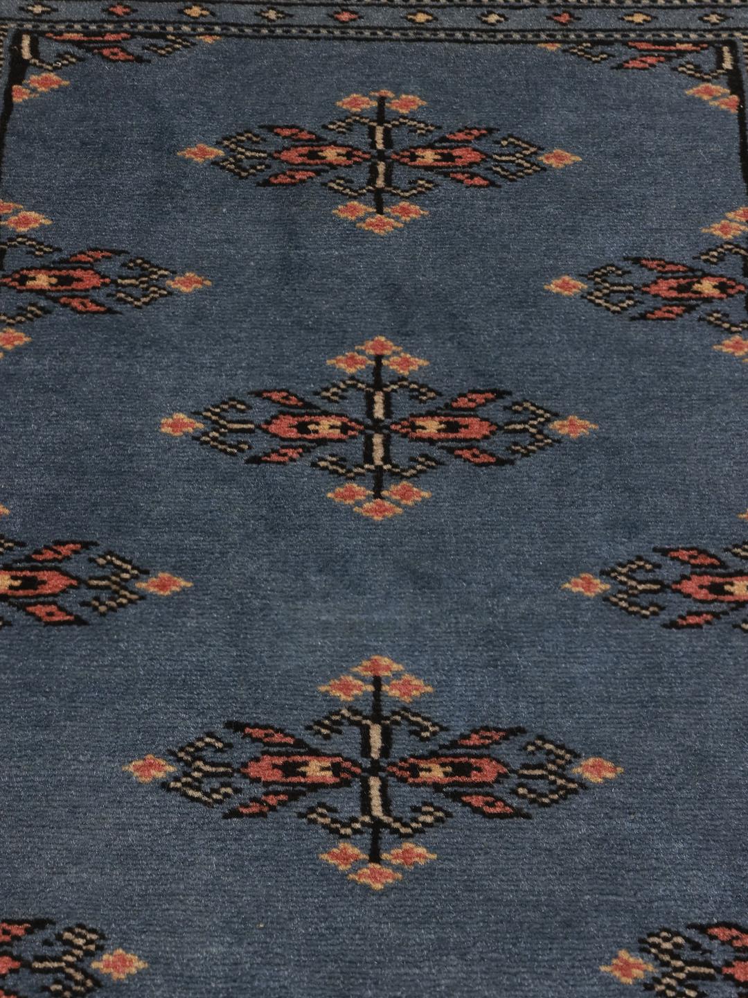 Handmade blue Pakistani rug with traditional motifs