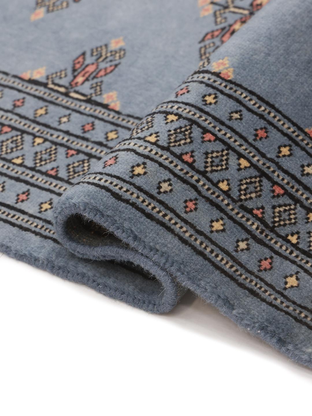 Handmade blue Pakistani rug with traditional motifs