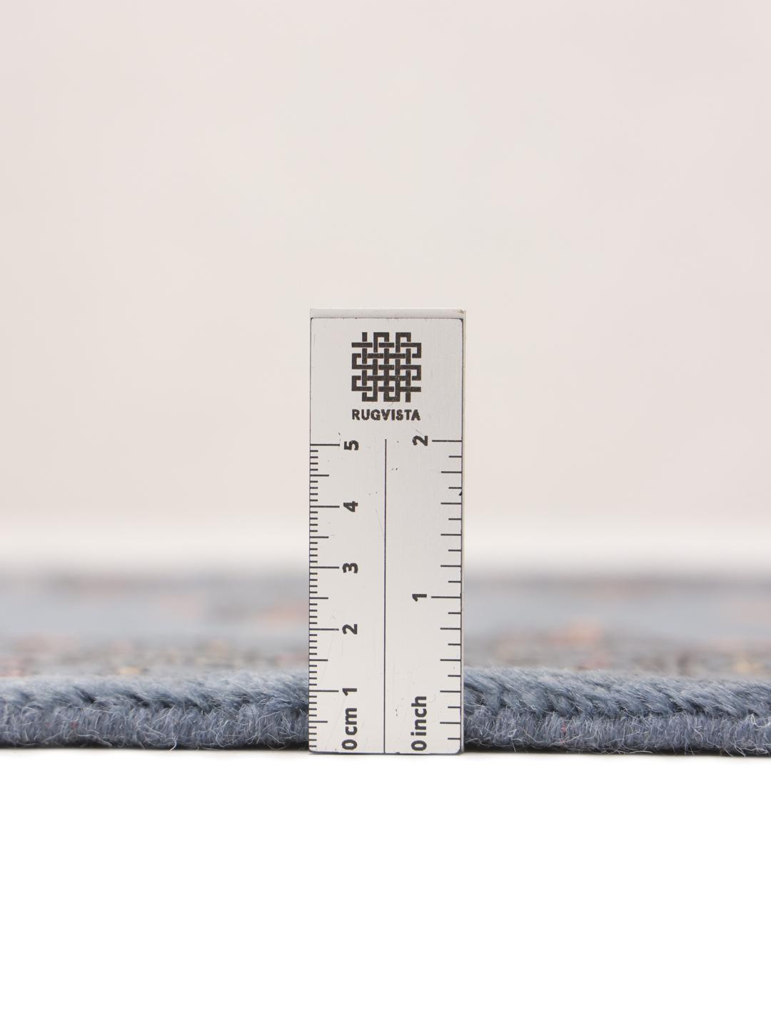 Handmade blue Pakistani rug with traditional motifs