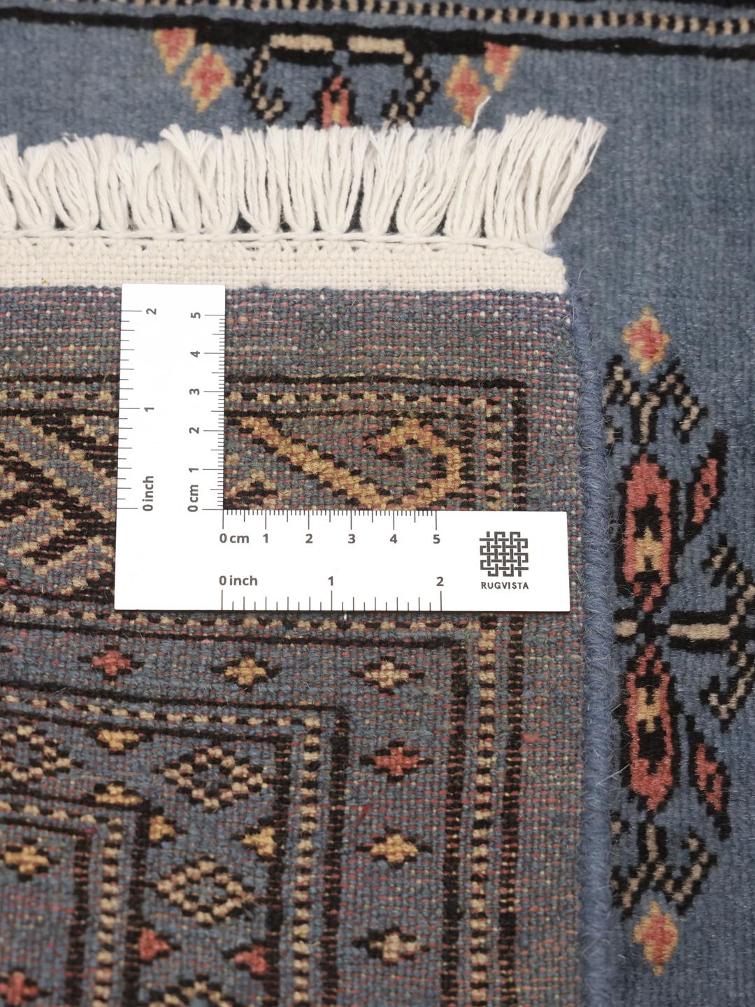 Handmade blue Pakistani rug with traditional motifs