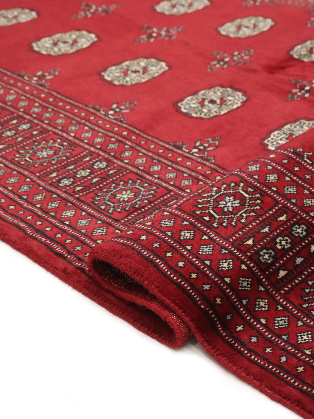 Hand-knotted Pakistani wool rug in dark-red with traditional geometric patterns