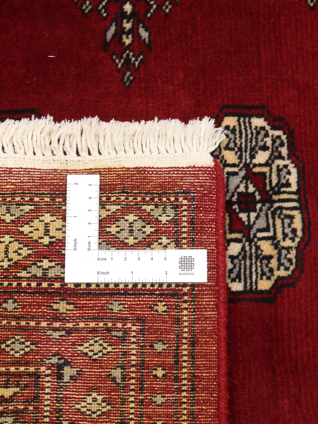 Hand-knotted Pakistani wool rug in dark-red with traditional geometric patterns