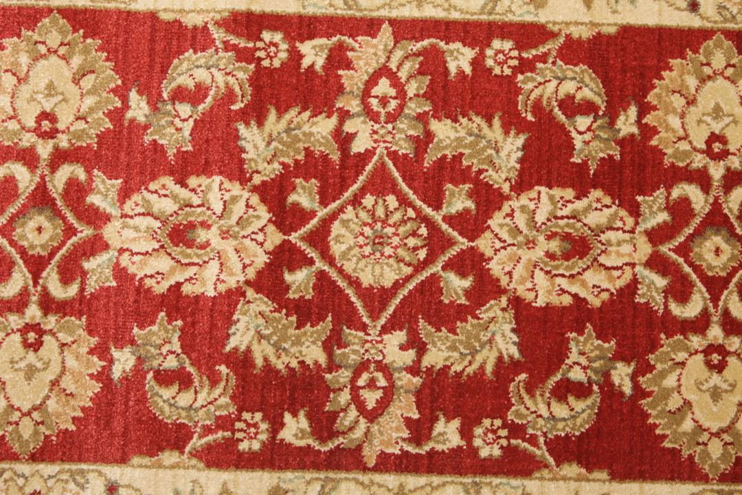 Rode loper met traditionele bloemmotieven en decoratieve randen