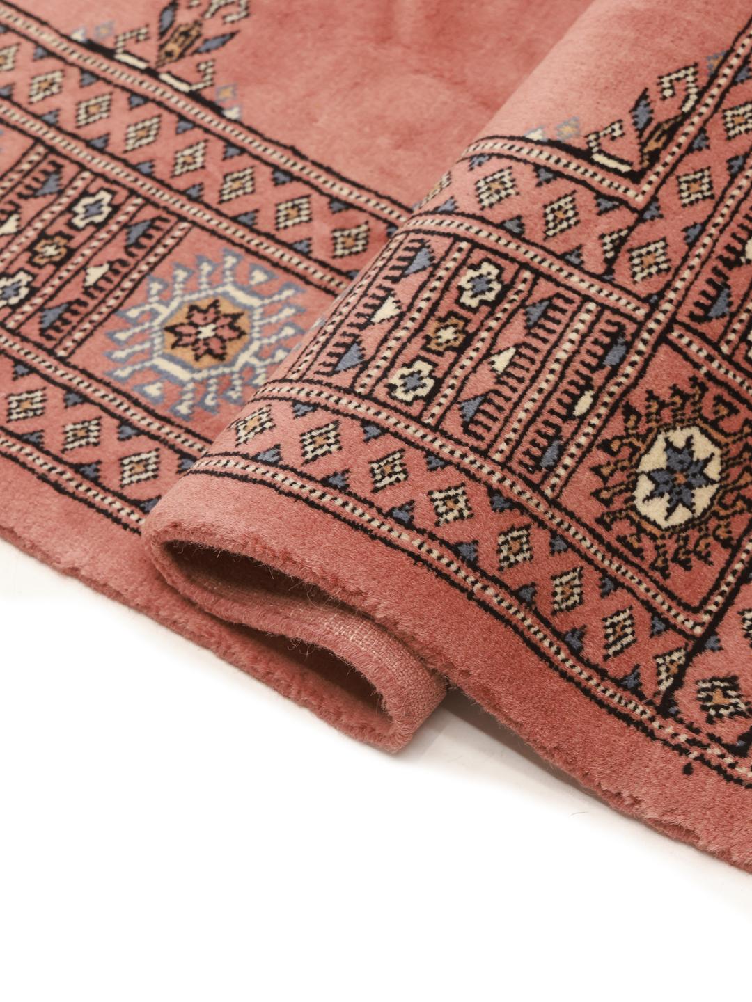Håndlavet pakistansk tæppe i mørkerød med traditionelle motiver
