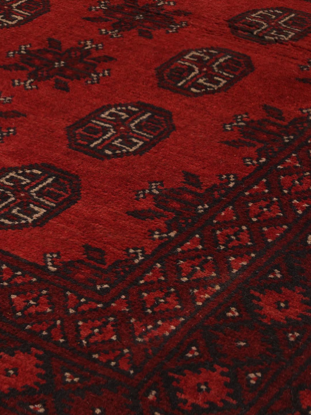 Håndlavet rødt afghansk tæppe med traditionelle motiver