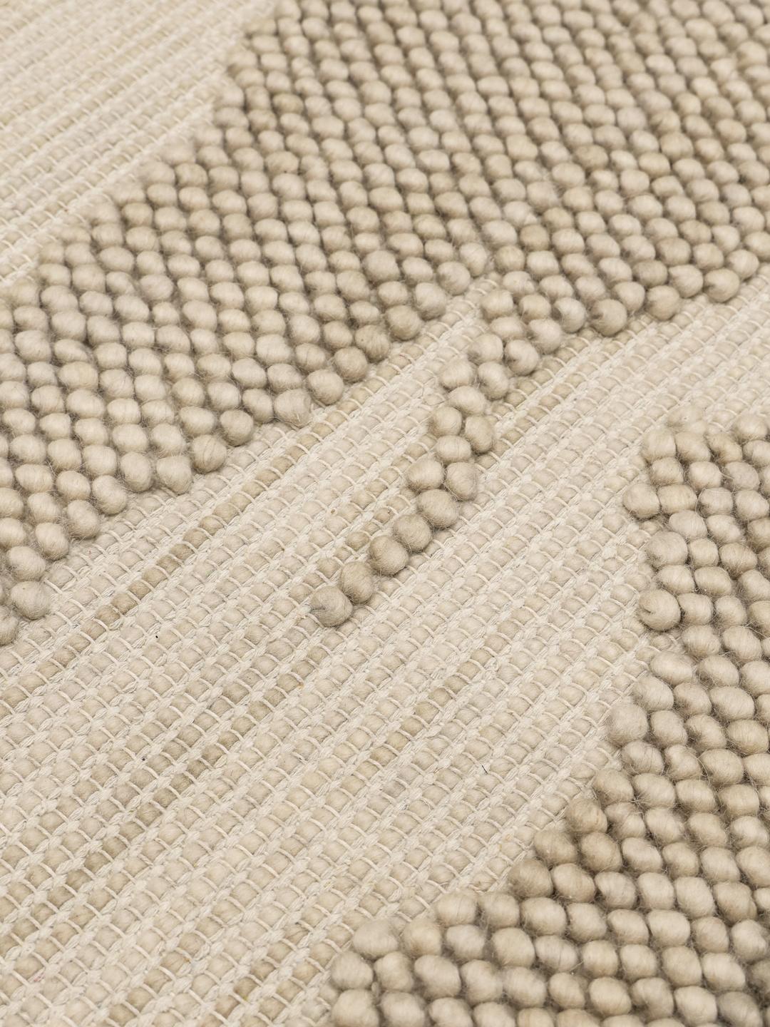 Handgeweven beige vloerkleed met een gestructureerd organisch patroon