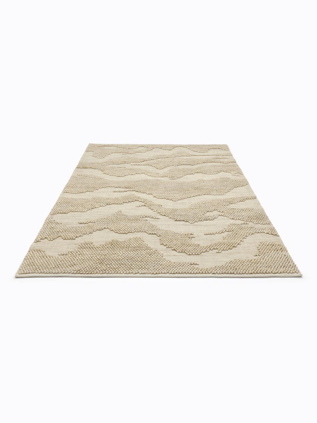 Handgeweven beige vloerkleed met een gestructureerd organisch patroon
