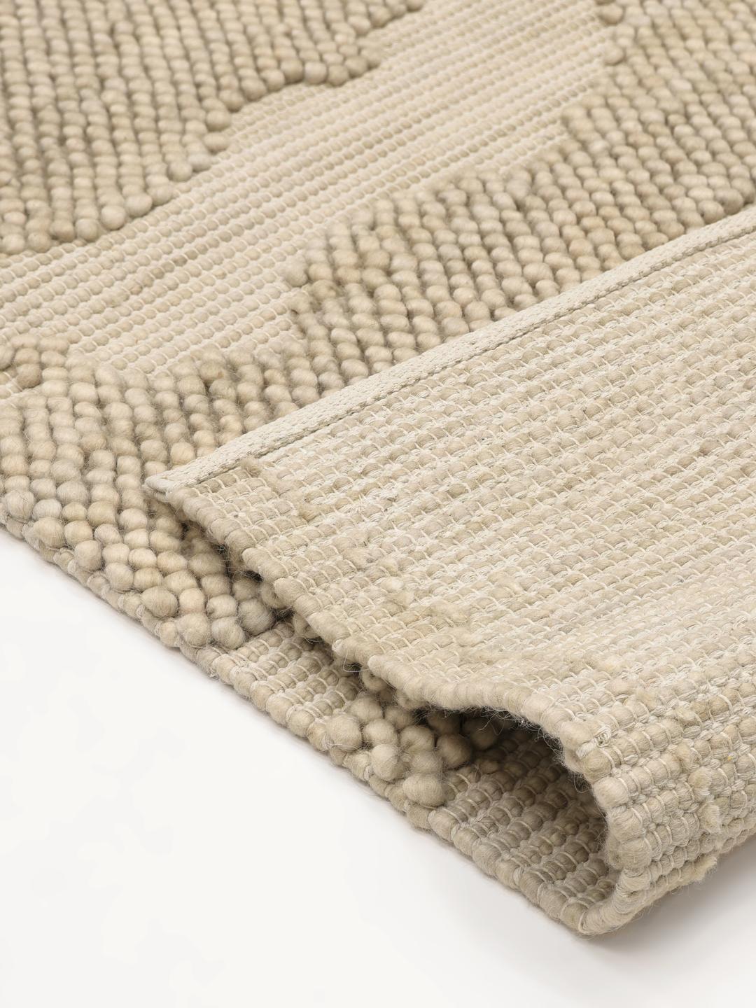 Handgeweven beige vloerkleed met een gestructureerd organisch patroon