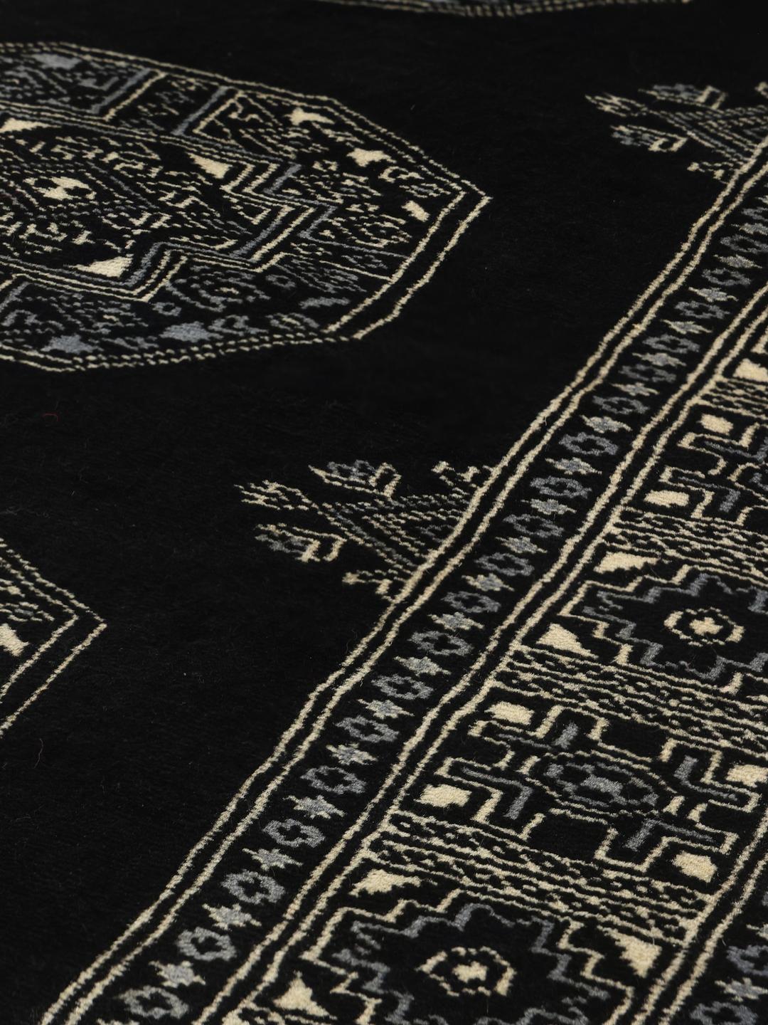 Handmade Bokhara rug from Pakistan in black with traditional motifs.