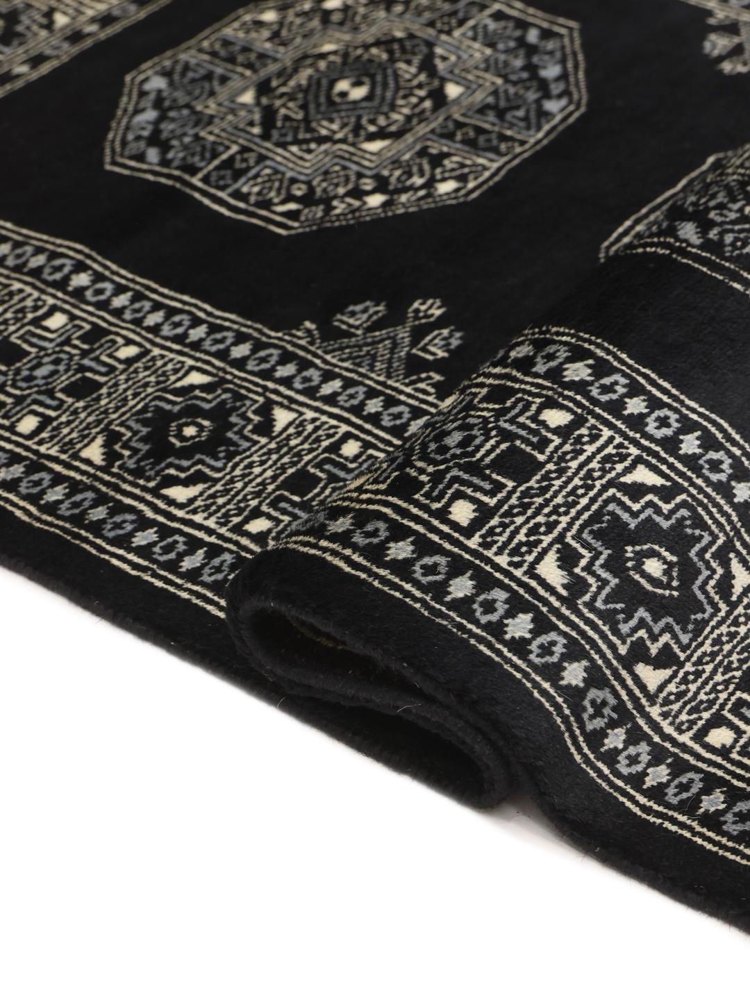 Handmade Bokhara rug from Pakistan in black with traditional motifs.