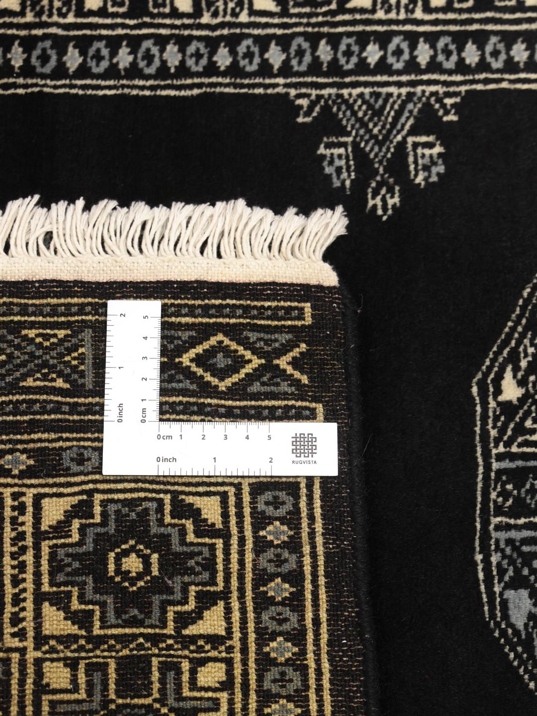 Handmade Bokhara rug from Pakistan in black with traditional motifs.