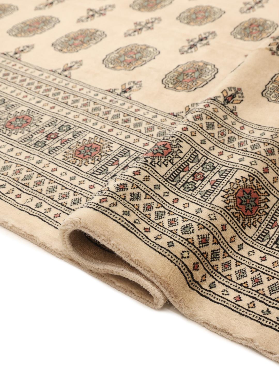 Håndknyttet beige Pakistan Bokhara-tæppe med traditionelle gul-motiver.