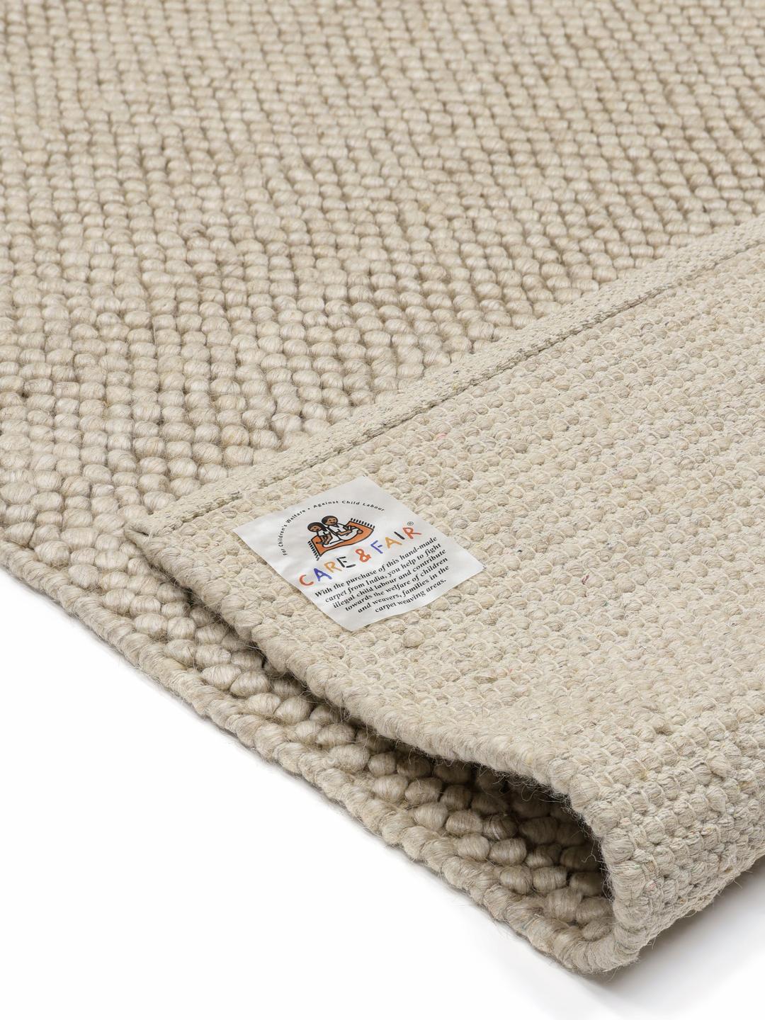 Beige wollen vloerkleed met gestructureerd oppervlak