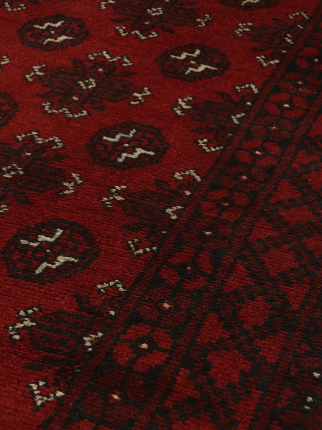 Hand-knotted runner rug from Afghanistan in dark red and black geometric patterns