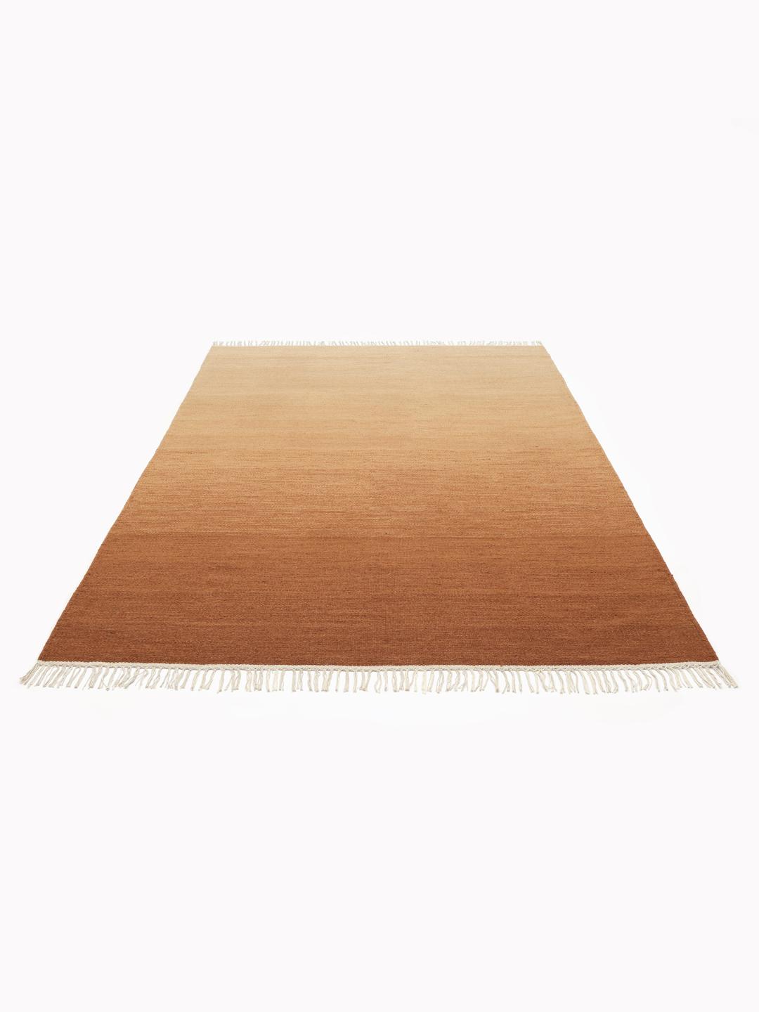 Handgeweven rood wollen vloerkleed met een warm ombre ontwerp en franjes