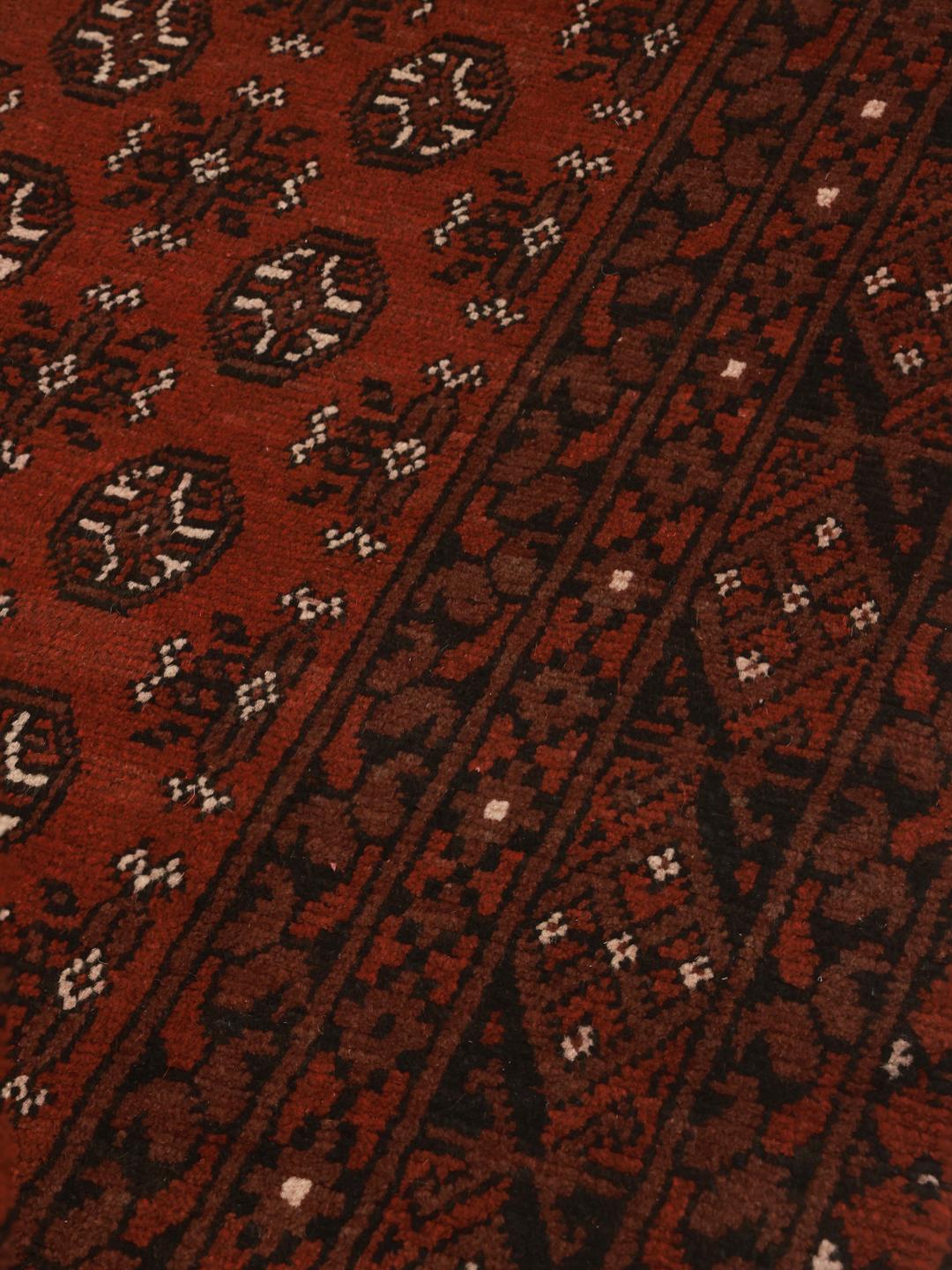 Rug originating from Afghanistan in dark-red
