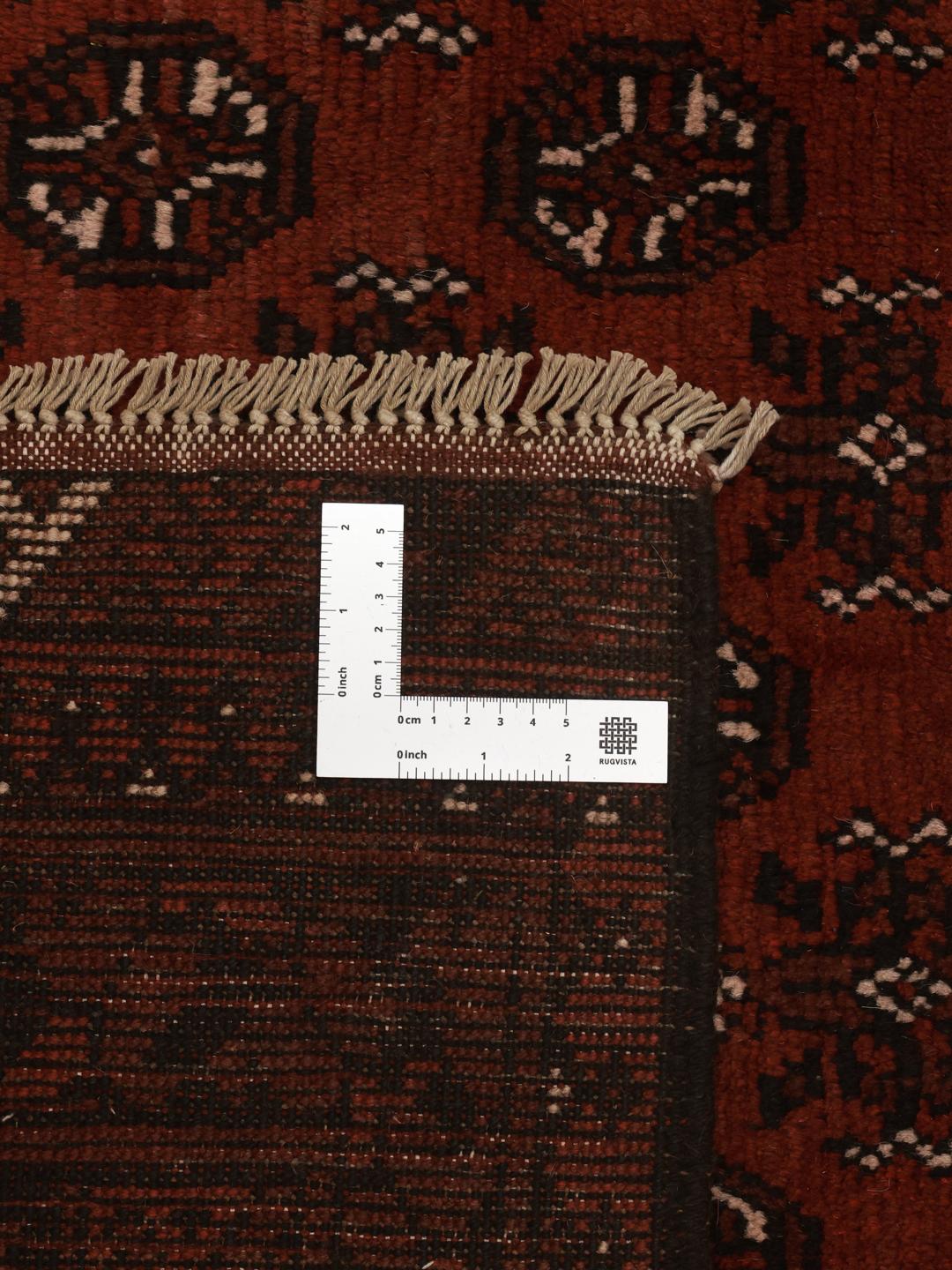 Rug originating from Afghanistan in dark-red