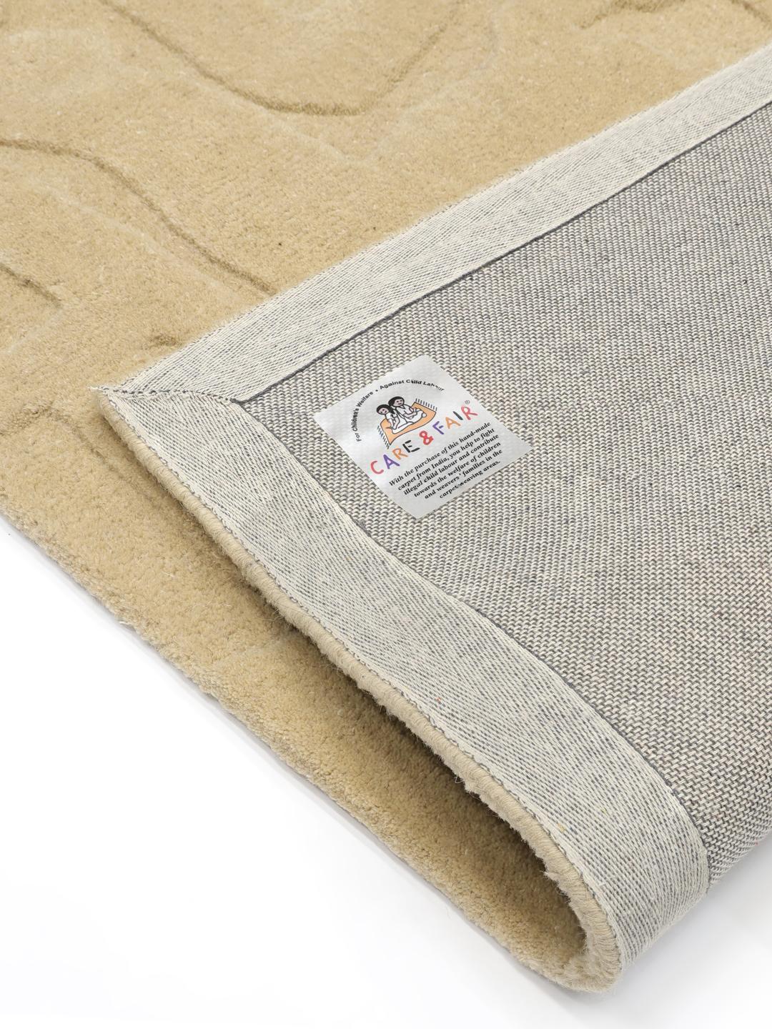 Een modern handgetuft beige vloerkleed met een abstract hoog-laag reliëfpatroon
