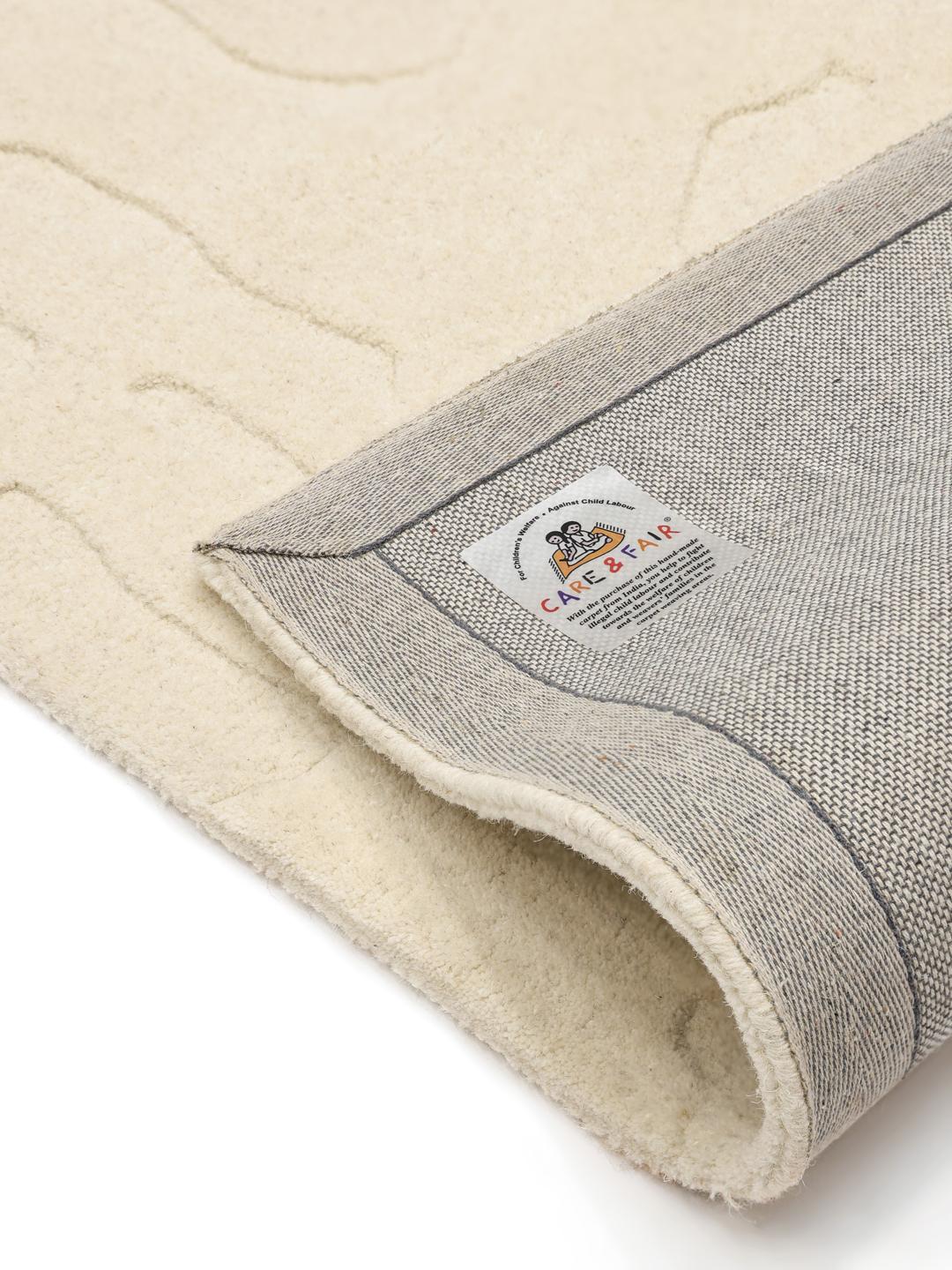 Met de hand getuft wit wollen vloerkleed met een gesneden reliëfpatroon