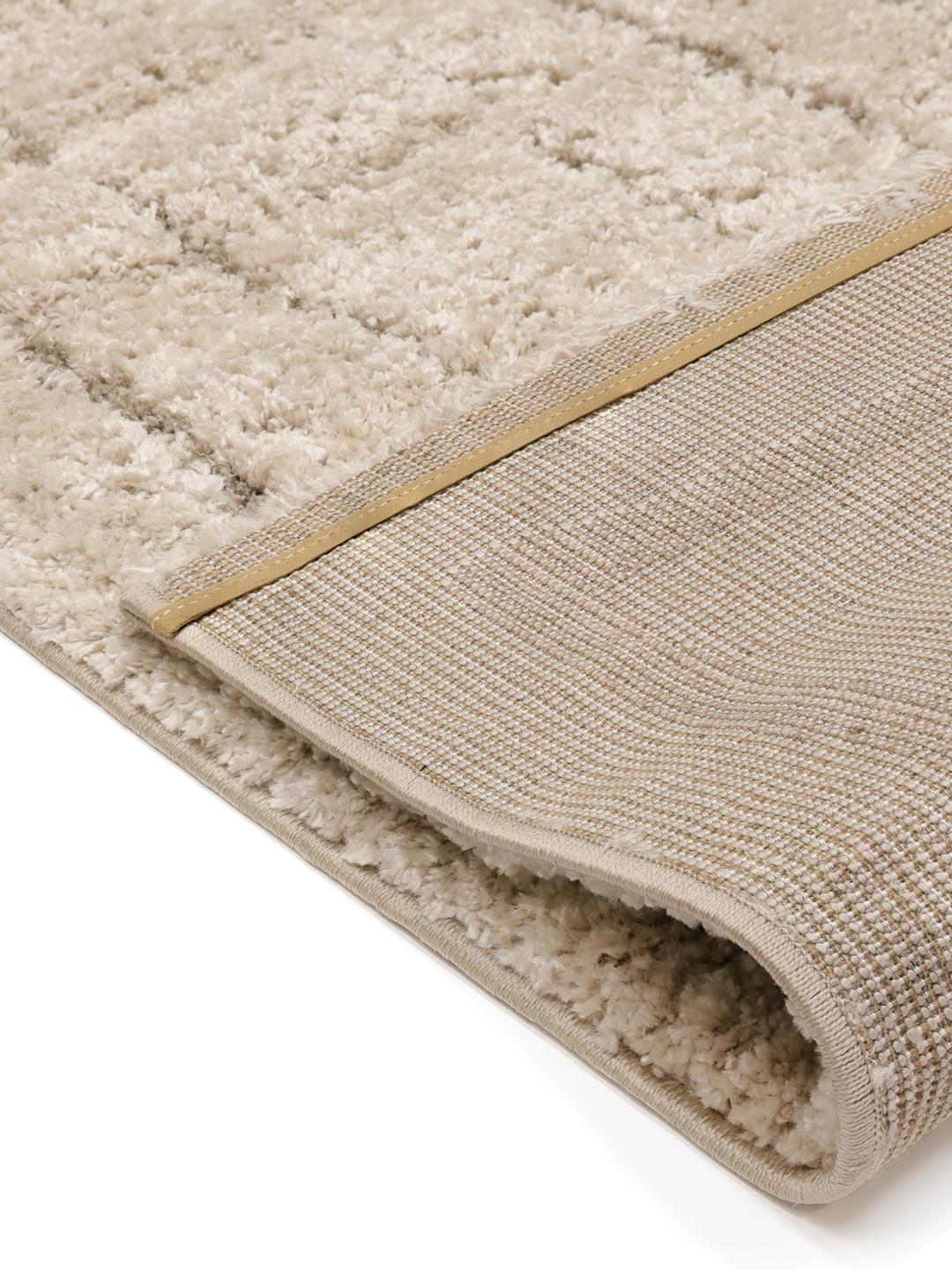 Een hoogpolig beige vloerkleed met organische concentrische rechthoekige lijnen