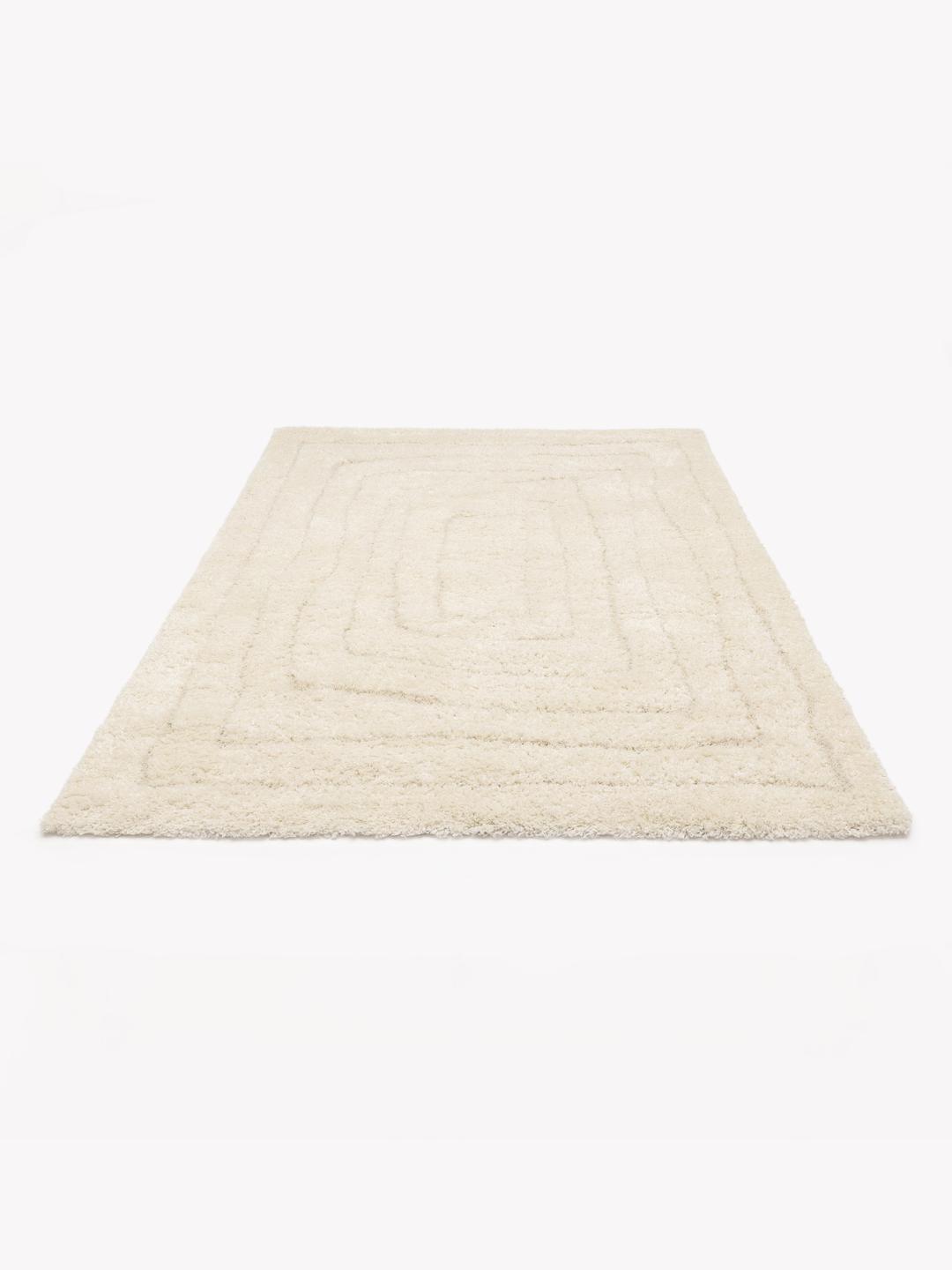 Een hoogpolig wit vloerkleed met een minimalistisch organisch lijnenpatroon