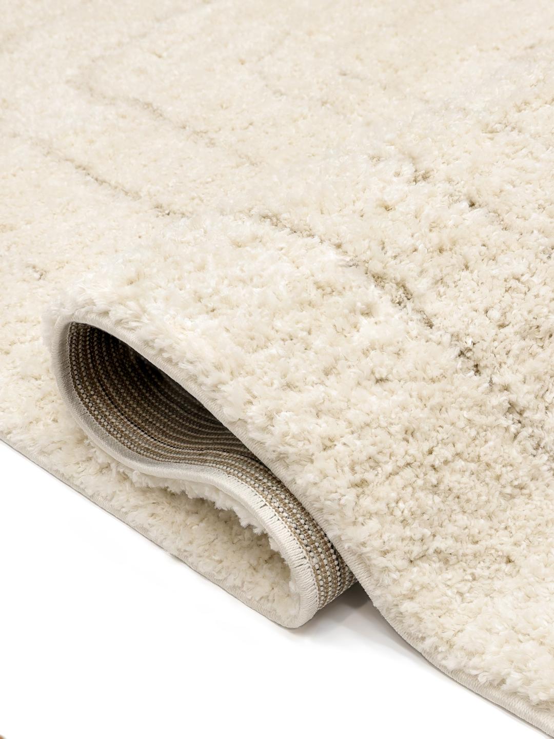 Een hoogpolig wit vloerkleed met een minimalistisch organisch lijnenpatroon
